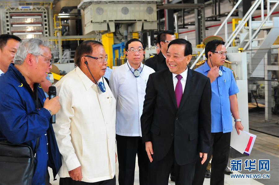 3月10日，在老撾沙灣拿吉省車邦縣，老撾人民革命黨中央總書記、國家主席本揚(yáng)（左二）在山東太陽紙業(yè)股份有限公司董事長李洪信（右二）的陪同下視察公司。 新華社記者章建華攝